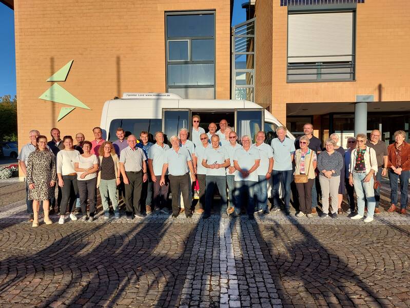 das Bild zeigt die Gruppe der ehrenamtlichen Bürgerbusfahrer mit der Vorstandschaft der Bürgergemeinschaft und Bürgermeister und weiteren GemeindevertreterInnen, alle stehen in 2 Reihen vor dem Bürgerbus, im Hintergrund ist das Rathausgebäude zu sehen, angestrahlt von der Abendsonne 